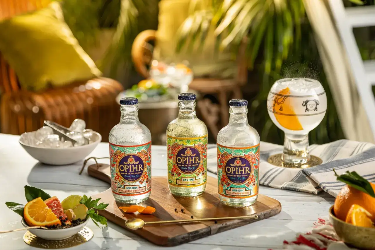 Drei Flaschen Opihr Gin & Tonic mit Zitrusfr&uuml;chten und Ingwer, bereit f&uuml;r einen erfrischenden Genuss.