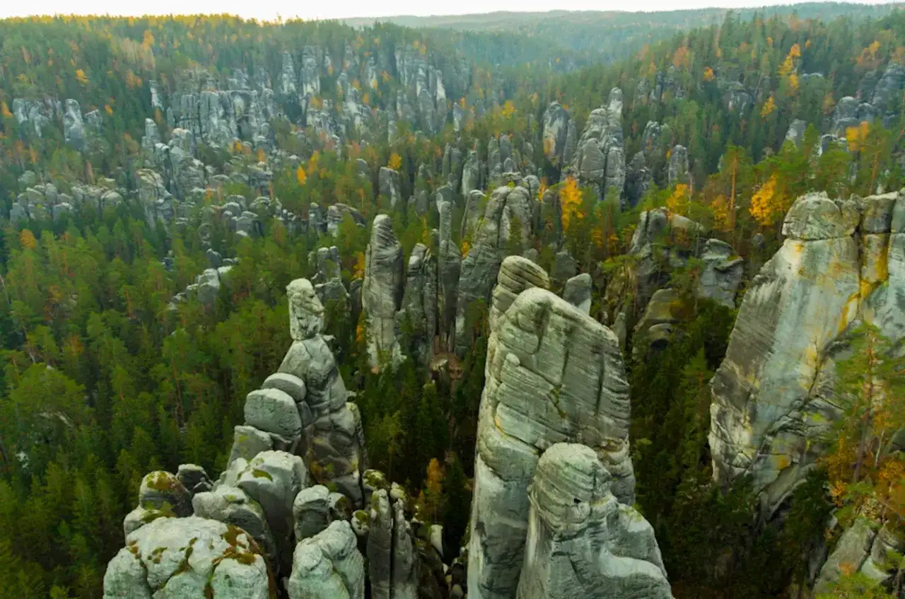 Imponujące skalne miasto w Teplicach, z iglicami skalnymi i lasem w jesiennych barwach.
