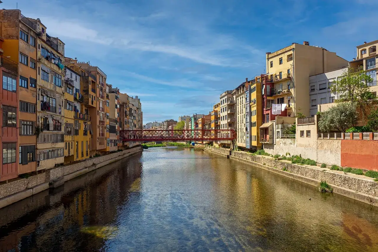 Kolorowe kamienice nad rzeką, czerwony most. Idealne miejsce, gdzie polecieć na weekend, by poczuć klimat Hiszpanii.
