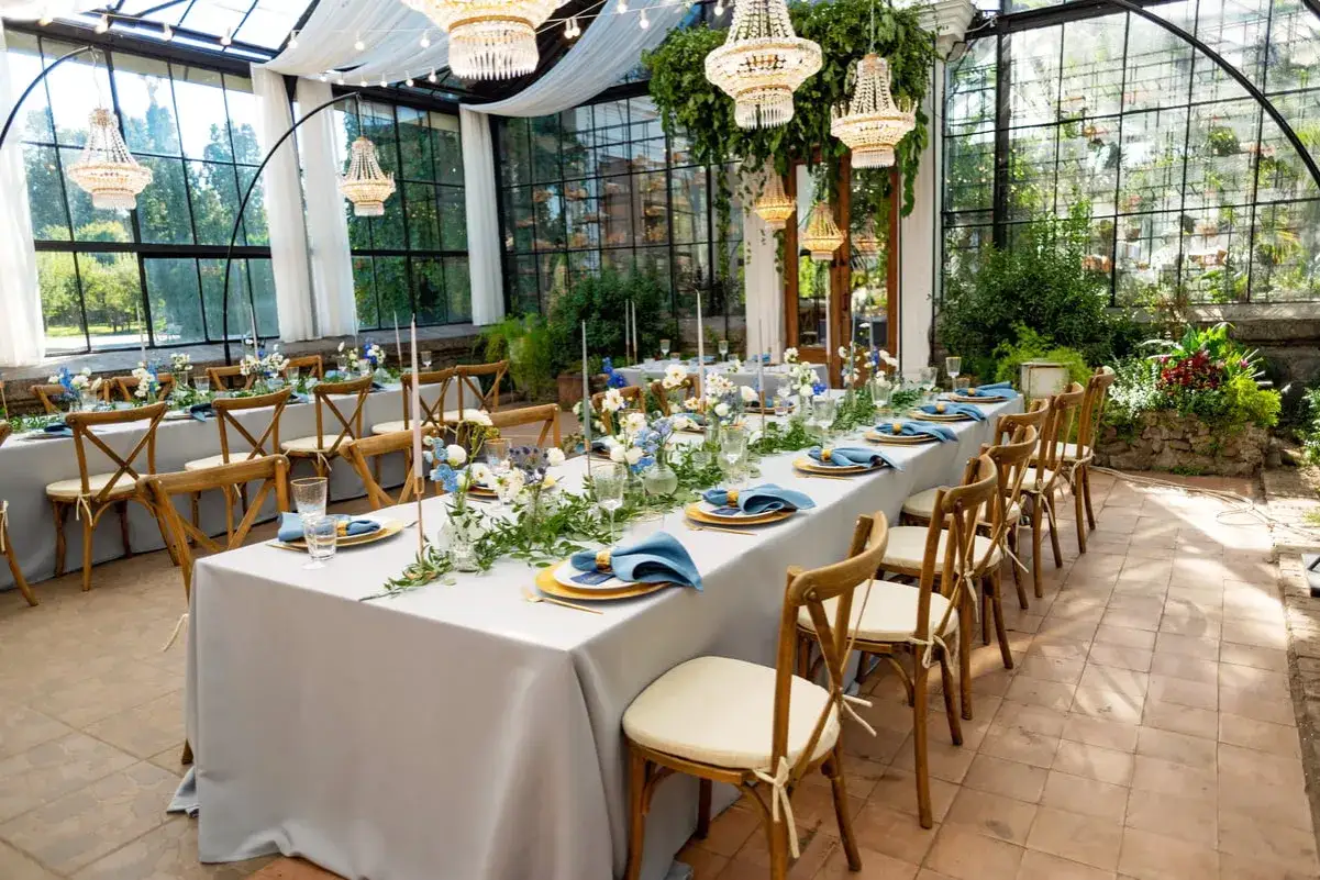 Tables dress&eacute;es pour 50 personnes, avec nappes grises, serviettes bleues et fleurs. Combien de m&egrave;tre de nappe pour 50 personnes ?