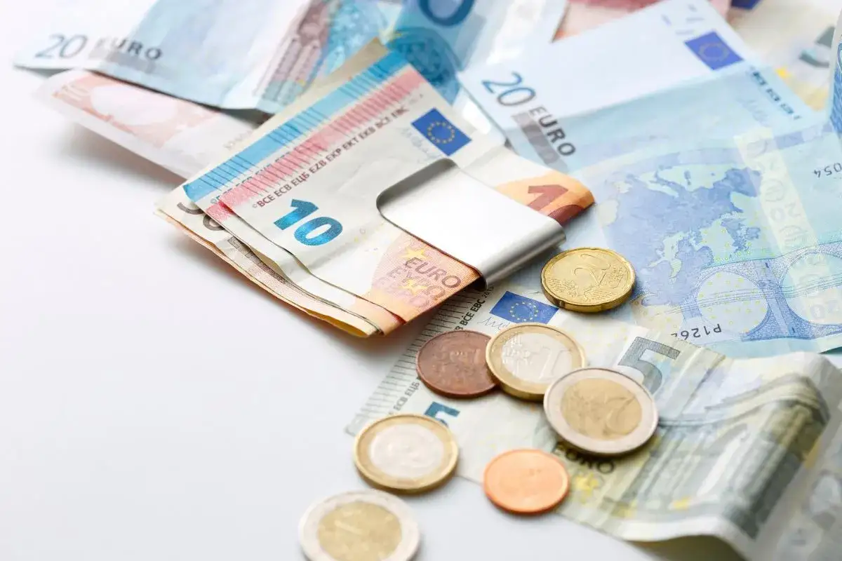 Euro banknoty i monety, w tym 10 i 20 euro, leżą na białym tle. To waluta w Grecji.
