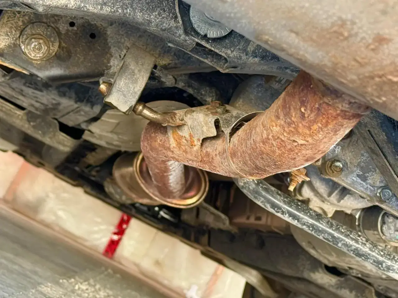 Rostig avgassystem på en Mitsubishi Colt, ett tydligt problem.