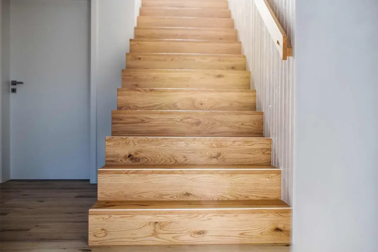 Moderne Holztreppe mit integrierter Beleuchtung. Tolle **Treppen renovieren Ideen** für ein warmes Ambiente.