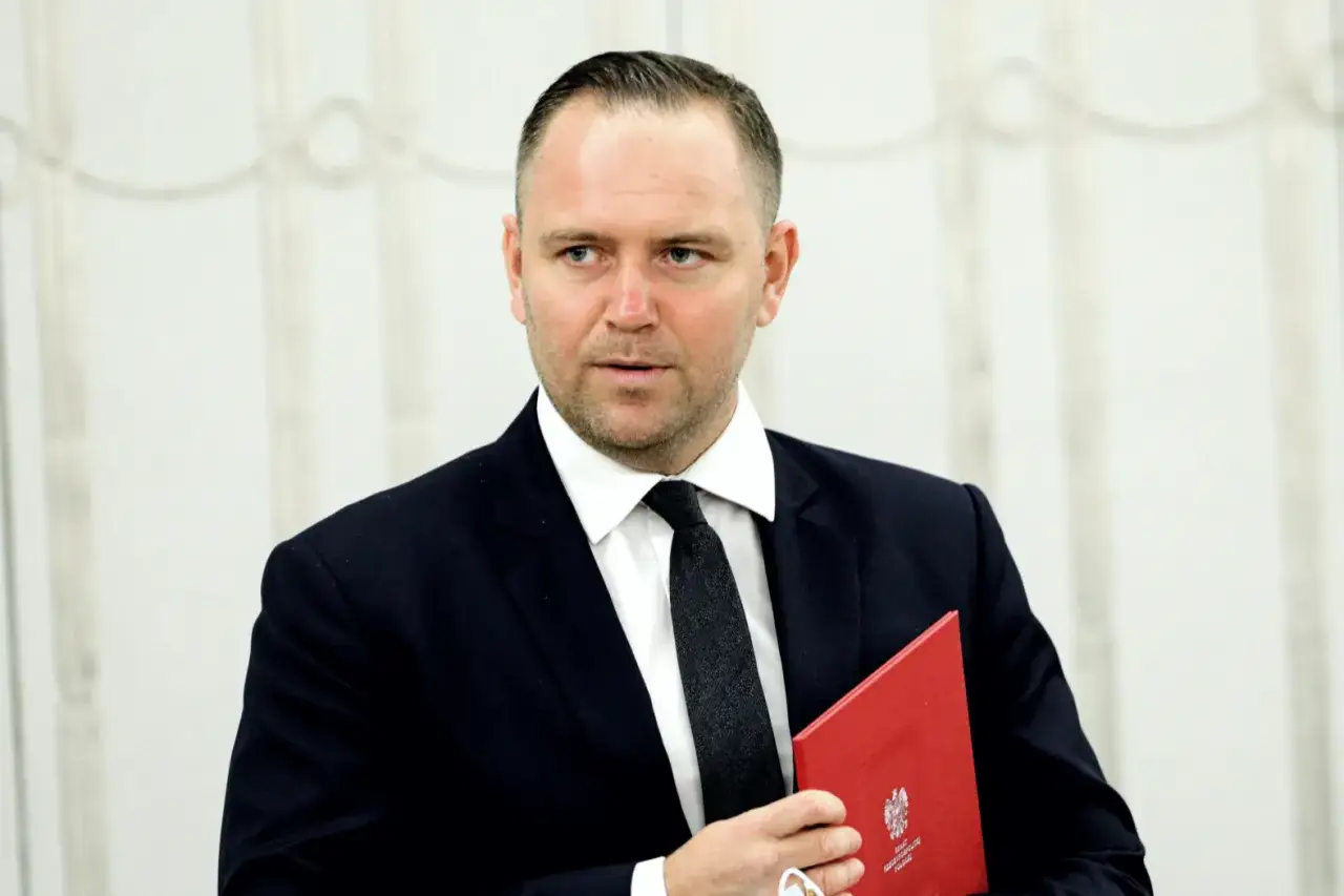 Karol Nawrocki w garniturze trzyma czerwony dokument. Jego wizerunek może być kluczem do tego, dlaczego Karol Nawrocki stał się nowym liderem sondaży zaufania na prawicy.