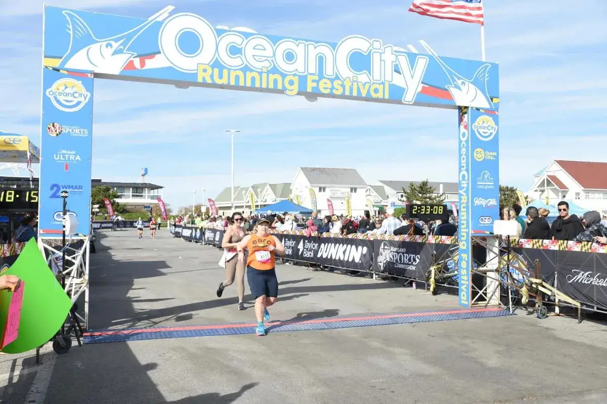 L&auml;uferinnen &uuml;berqueren die Ziellinie beim Ocean City Running Festival. Die halbmarathon distanz ist geschafft!