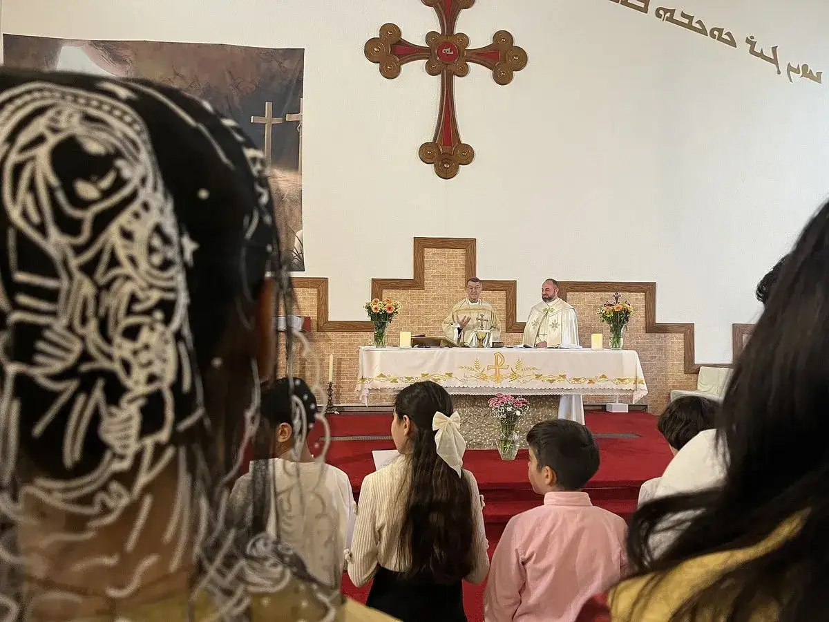 Gottesdienst in der United Church of Christ. Zwei Geistliche am Altar, Kinder im Vordergrund.