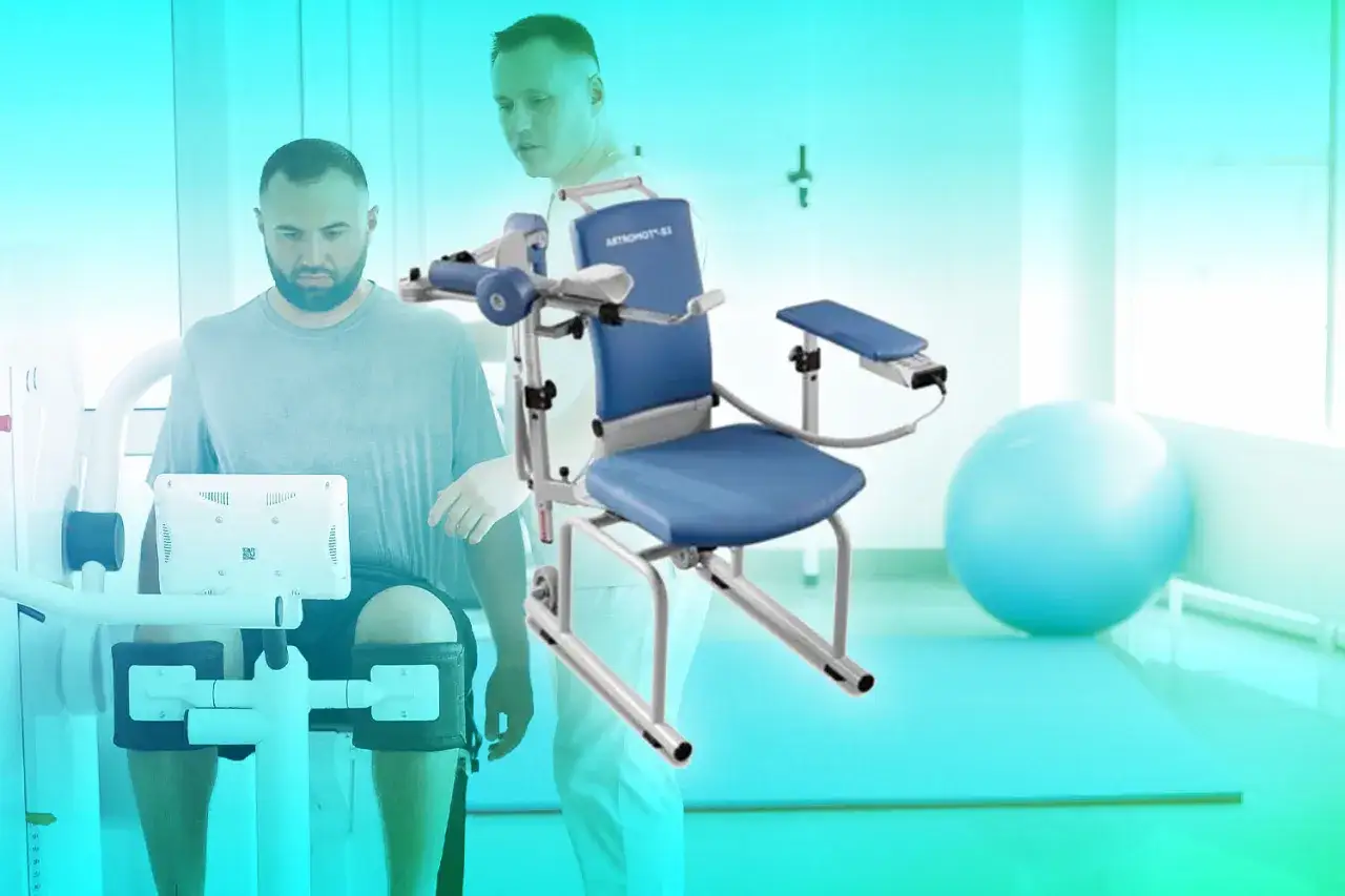 Pacjent na urządzeniu rehabilitacyjnym, pielęgniarka wspiera go. To przykład funkcji rehabilitacyjnej pielęgniarki.