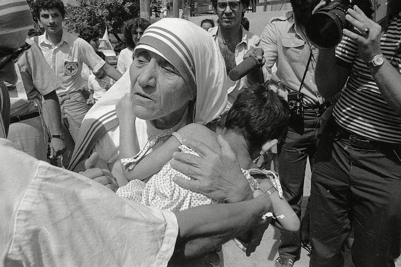 Mutter Teresa tr&ouml;stet ein Kind. Sie hat ihr Leben der Hilfe f&uuml;r die Armen und Kranken gewidmet.