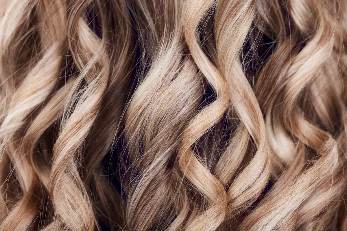 Falujące, jasne blond włosy z subtelnymi refleksami, jak po letnim słońcu. Efekt flamboyage dodaje im głębi i naturalności.