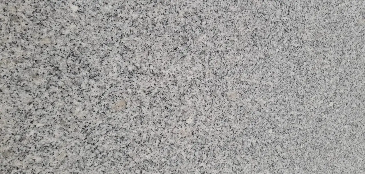 Textura de jaspe blanco con motas grises y negras. Sus propiedades lo hacen ideal para encimeras y revestimientos.