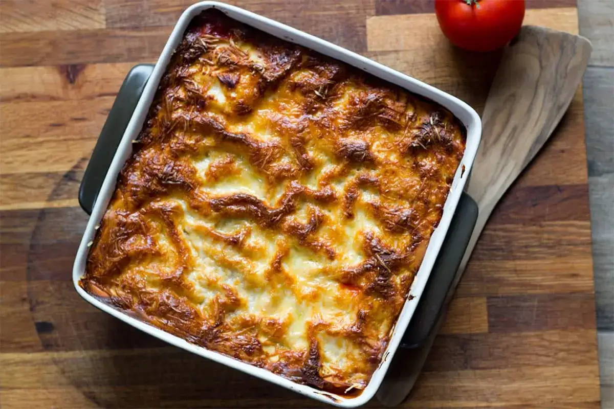 Lasagne diététique dorée et gratinée dans un plat blanc, prête à être dégustée. Un délice léger pour un repas sain.