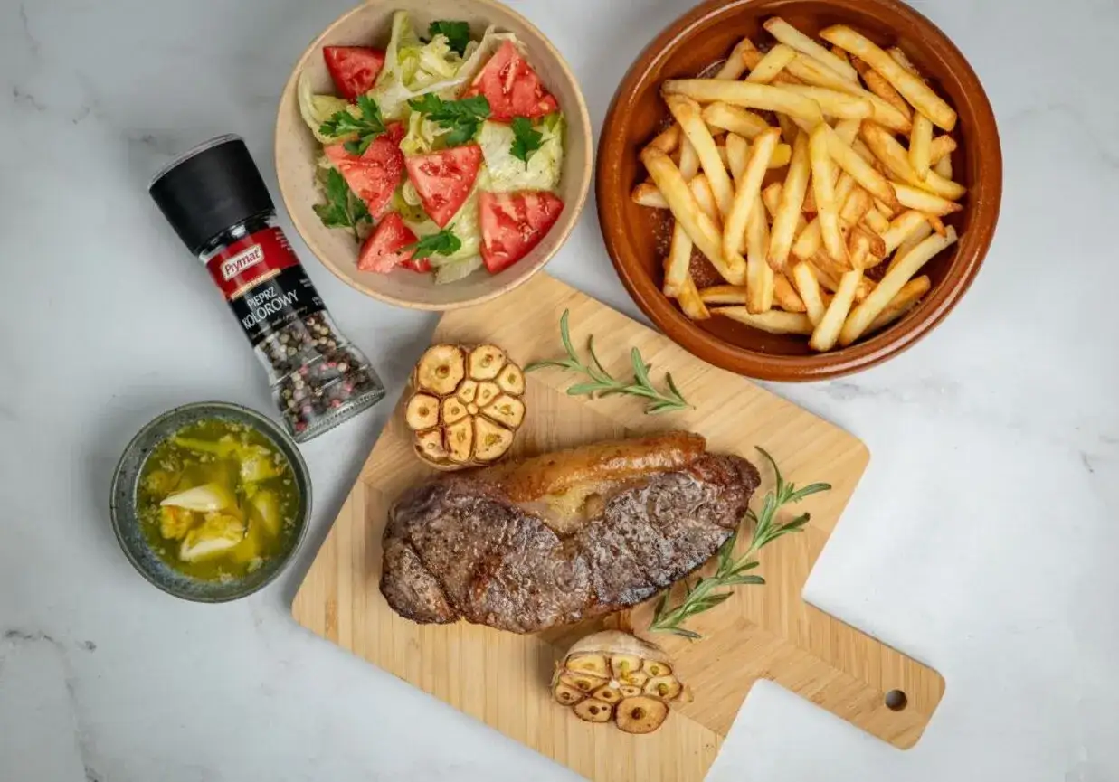 Pyszny stek z airfryer, podany z frytkami, sałatką i pieczonym czosnkiem. Idealny obiad!