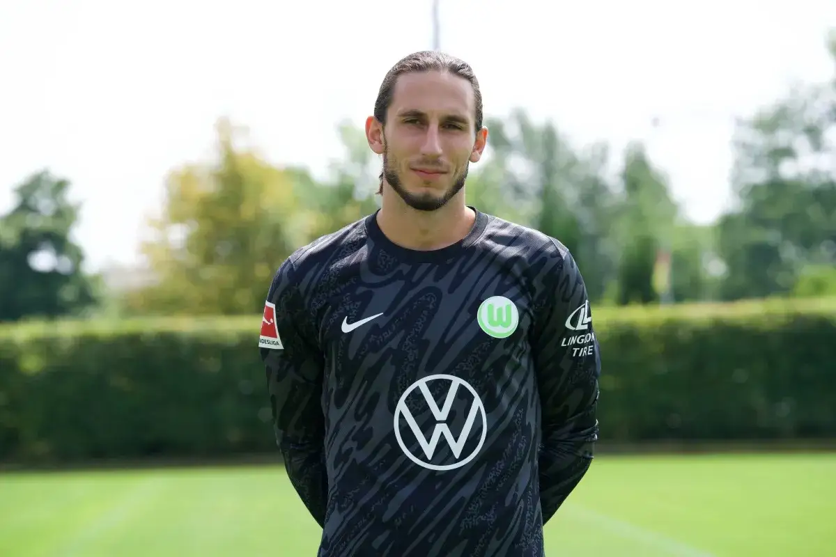 Kamil Grabara w stroju bramkarskim VfL Wolfsburg. Jego obecne drużyny to kluby Bundesligi.