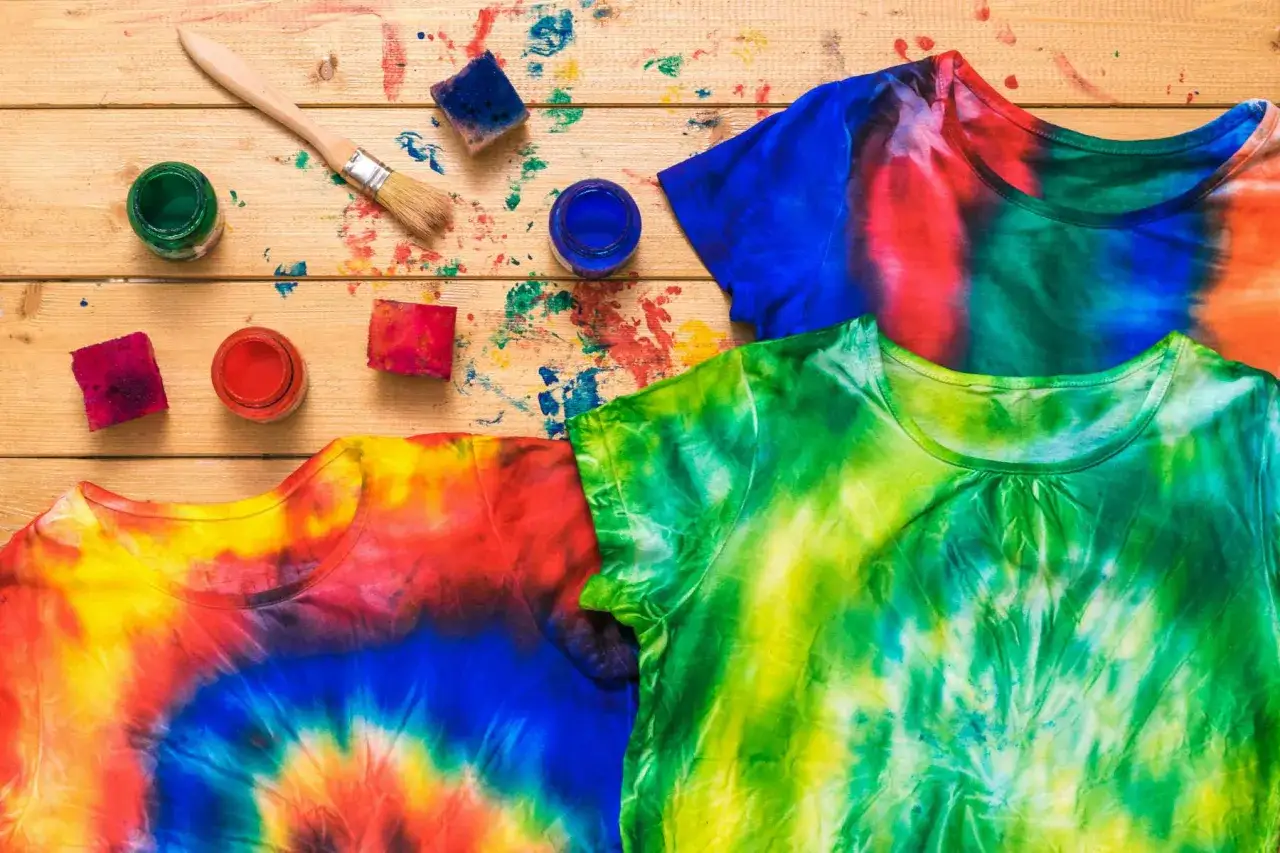 Bunt gef&auml;rbte T-Shirts und Bastelmaterialien f&uuml;r das Batiken mit Kindern.