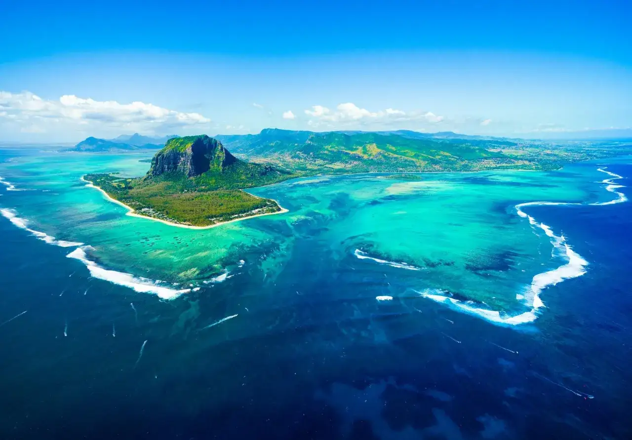 Widok z lotu ptaka na Le Morne Brabant na Mauritiusie, z turkusową wodą i białymi falami. Nawet podczas mauritius pora deszczowa, krajobraz zachwyca.