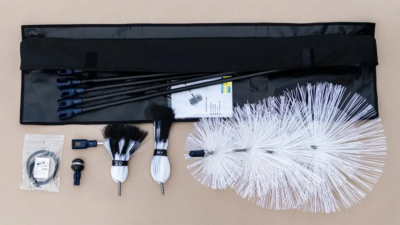 Werkzeugset f&uuml;r die Kaminreinigung: B&uuml;rsten, Stangen und Zubeh&ouml;r in einer schwarzen Tasche. Perfekt f&uuml;r die anzug reinigung.
