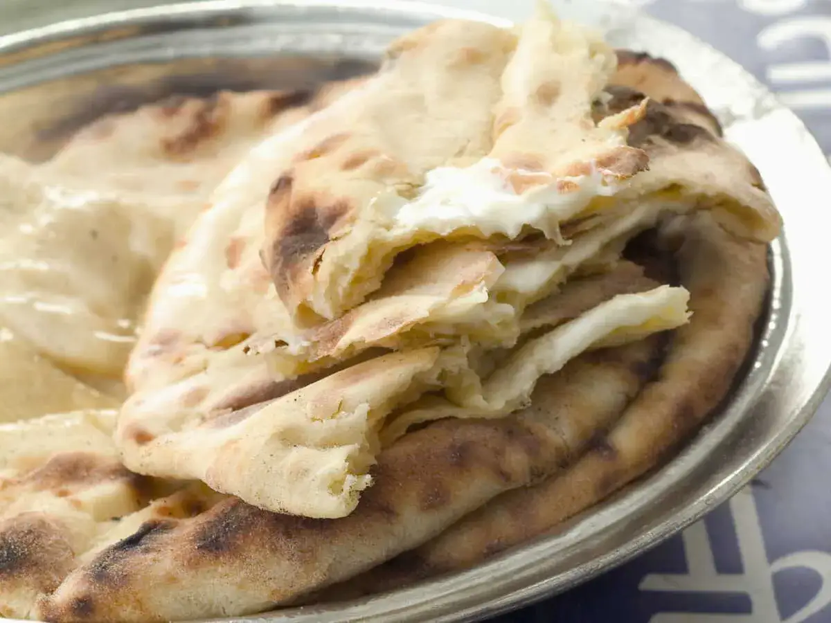 Naan moelleux garni d'un fromage fondant, rappelant la douceur de la vache qui rit. Un délice à partager.