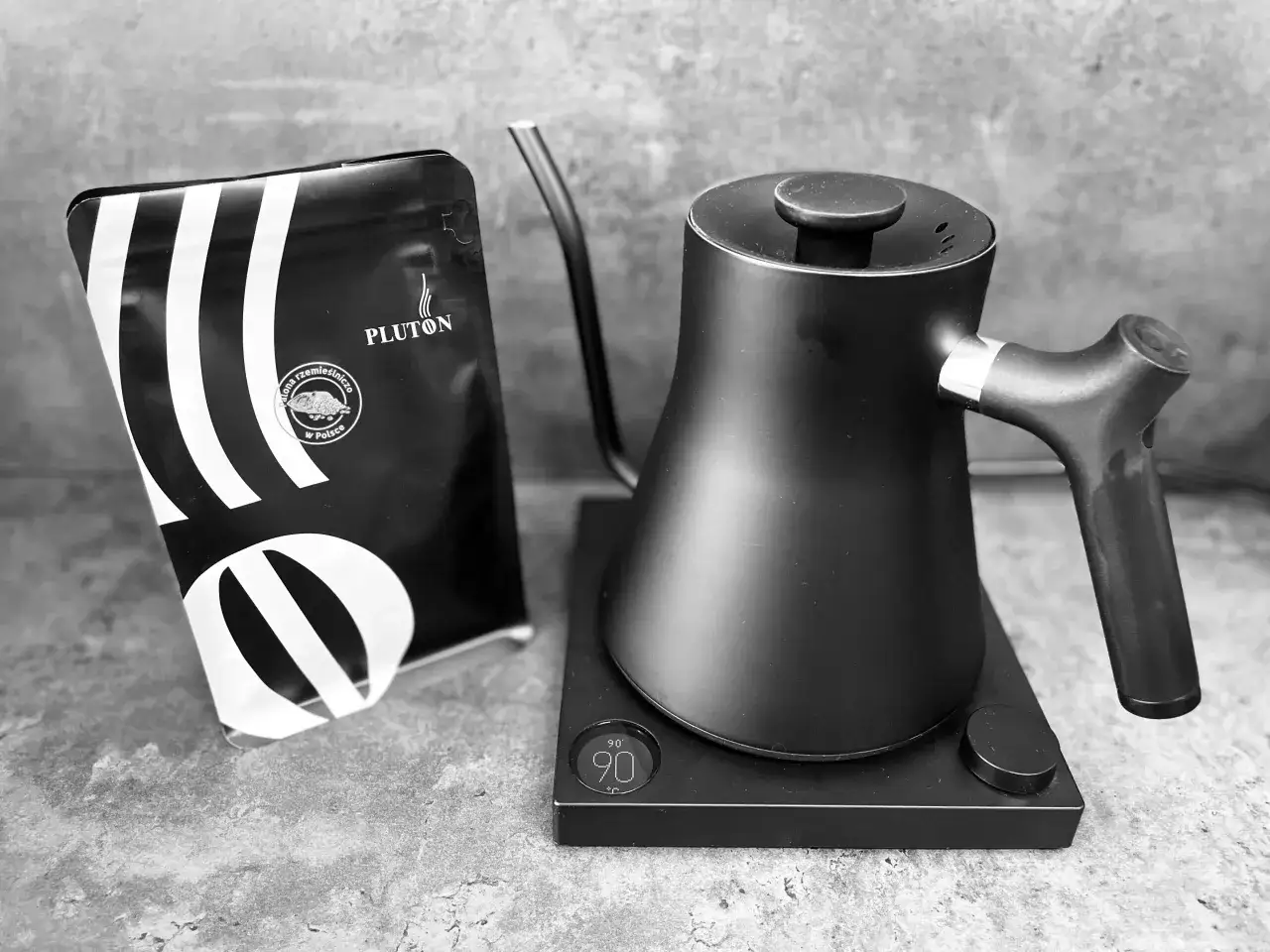 Czarna czajnik z precyzyjnym wylewem i opakowanie kawy PLUTON. Idealny zestaw do zaparzenia wyśmienitej kawy z french press.