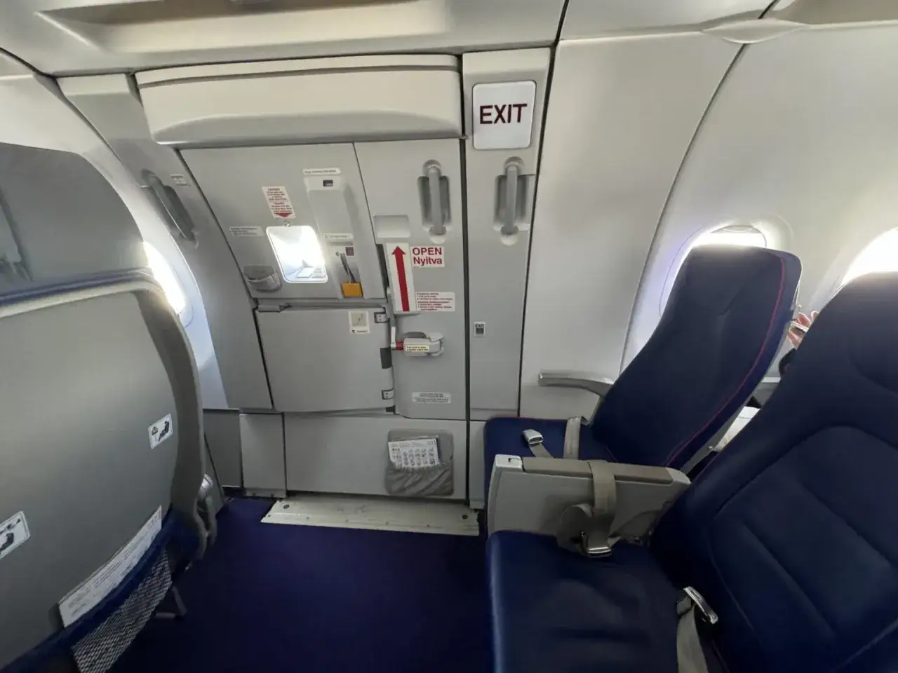 Wizz rozkład miejsc w samolocie Wizzair. Widok na rząd siedzeń i drzwi wyjściowe.