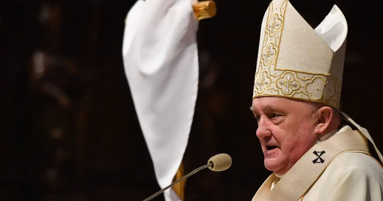 Biskup w mitrze i szatach liturgicznych przemawia do mikrofonu. Czy biskup to zawód? To powołanie i służba.
