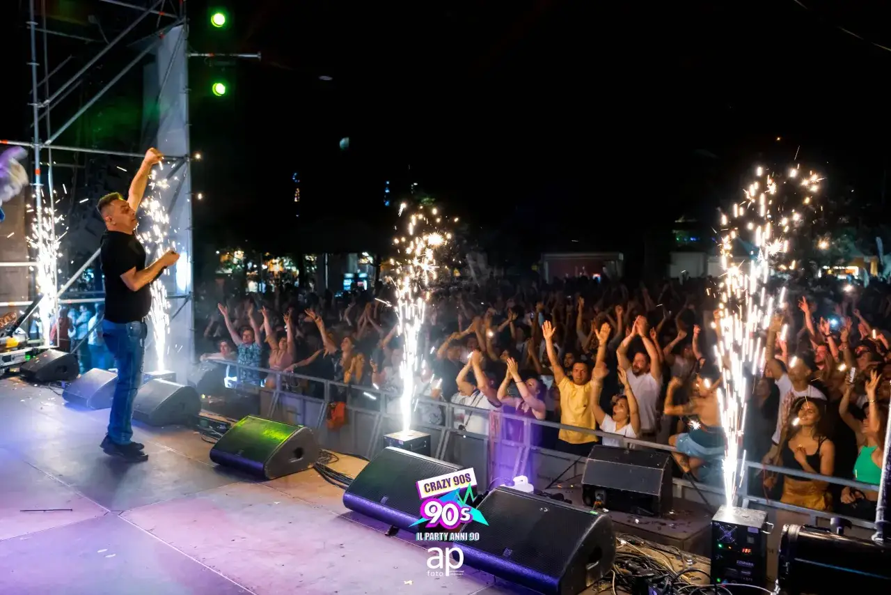 Un cantante sul palco con fuochi d'artificio, una folla entusiasta al concerto della nuovanta band 