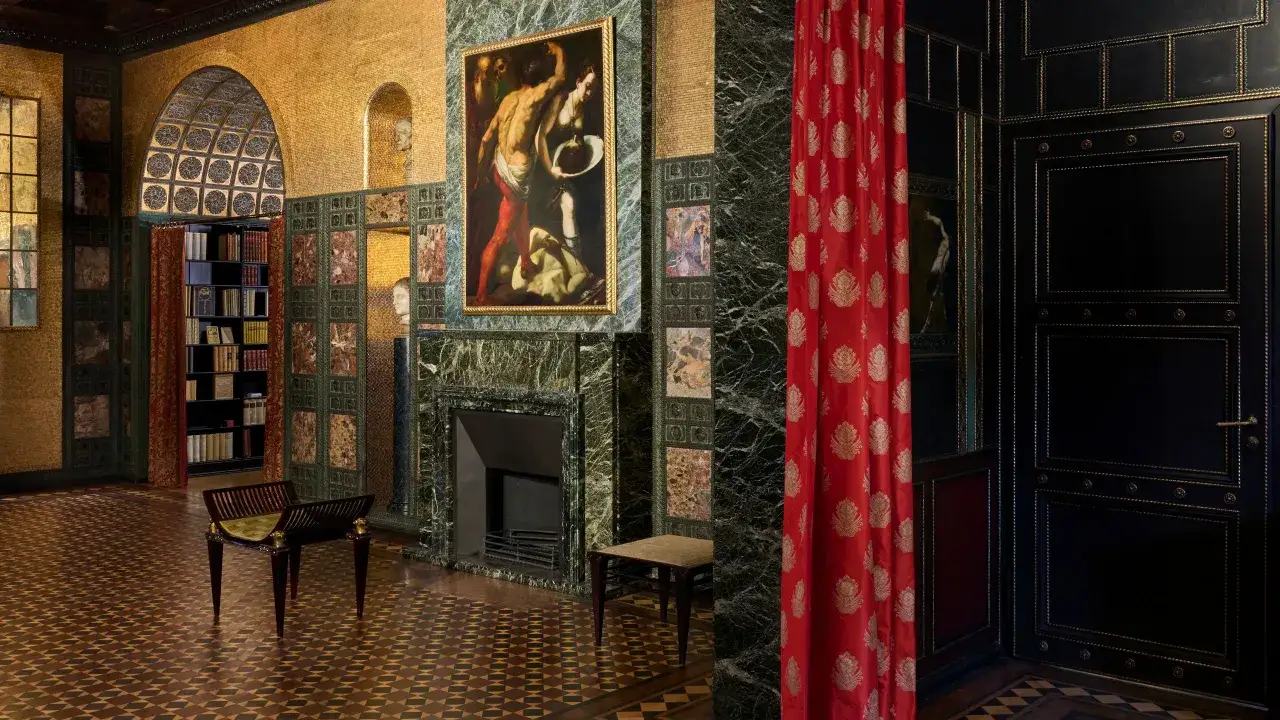Ein prunkvoller Raum mit Mosaiken, Marmor und einem Gem&auml;lde, das an Symbolismus Kunst erinnert. Ein roter Vorhang verdeckt einen Teil des Raumes.