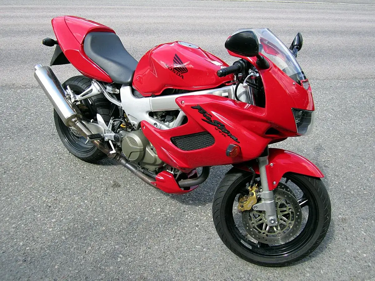 Czerwony motocykl Honda VTR 1000 Firestorm zaparkowany na asfalcie.