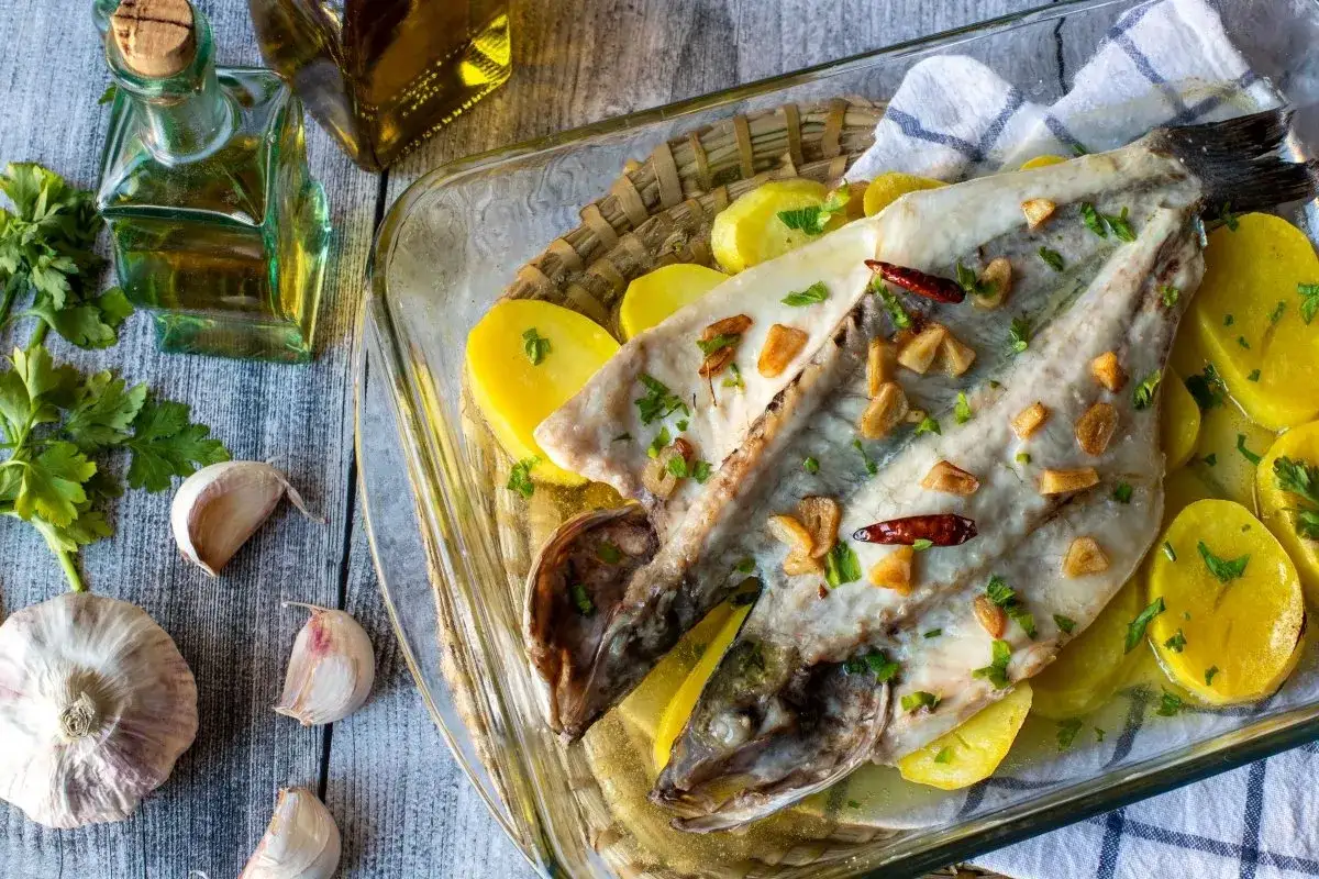 Lubina a la donostiarra horneada con patatas, ajo y guindilla. Un plato delicioso y sencillo.