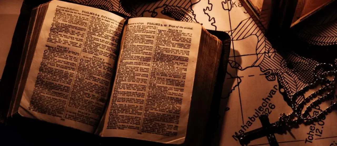 An open Bible with Psalms, a rosary, and a map. The text asks, 