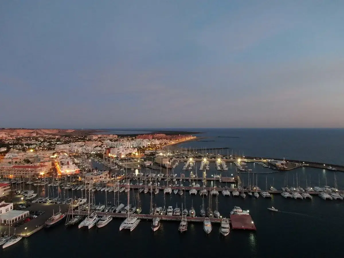 Vista aérea del puerto deportivo de Almerimar al atardecer, con multitud de veleros y yates. Descubre qué ver en Almerimar.