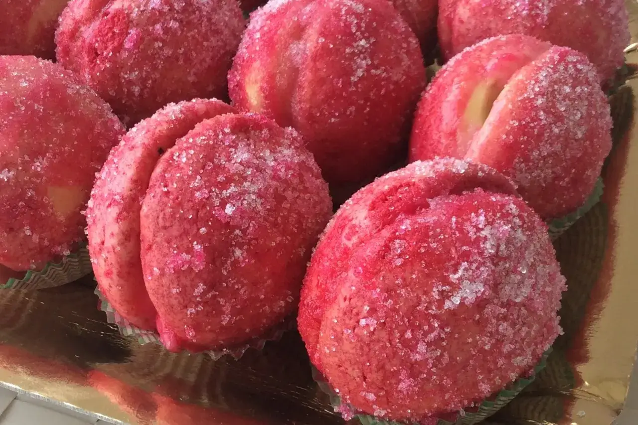 Dolci e sofficissime pesche ricoperte di zucchero scintillante, pronte per essere gustate.