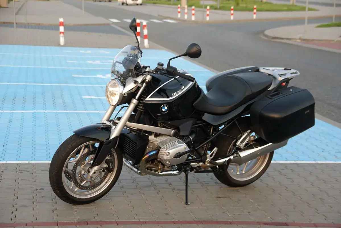 Czarny motocykl BMW R1200R z kuframi, gotowy na podróż.