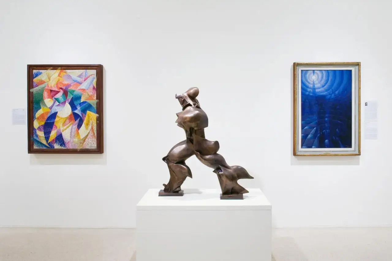 Scultura dinamica e due dipinti astratti in una galleria, un'esposizione che Peggy Guggenheim avrebbe ammirato.