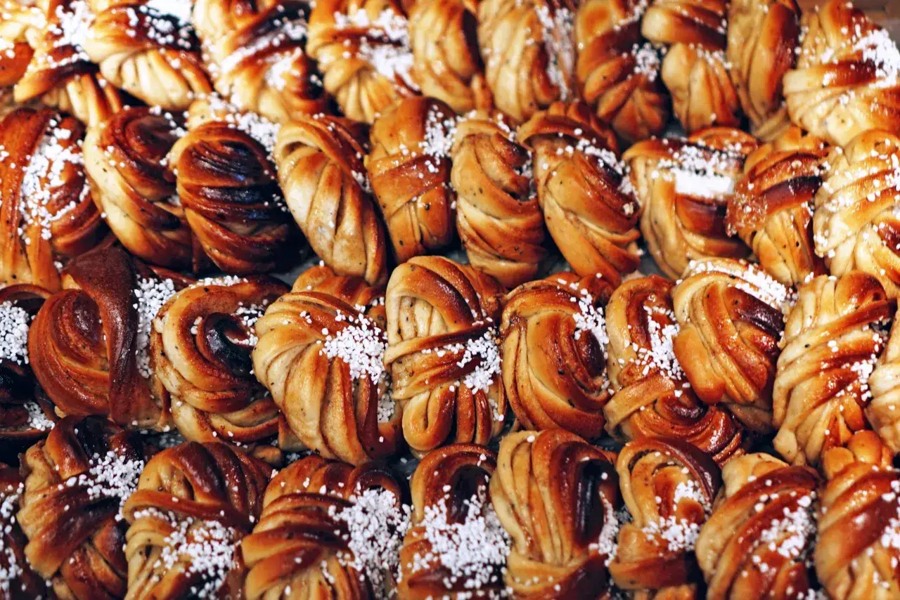 En n&auml;rbild p&aring; kanelbullar, en klassisk svensk fika. Dessa gyllene bakverk &auml;r str&ouml;sslade med p&auml;rlsocker.