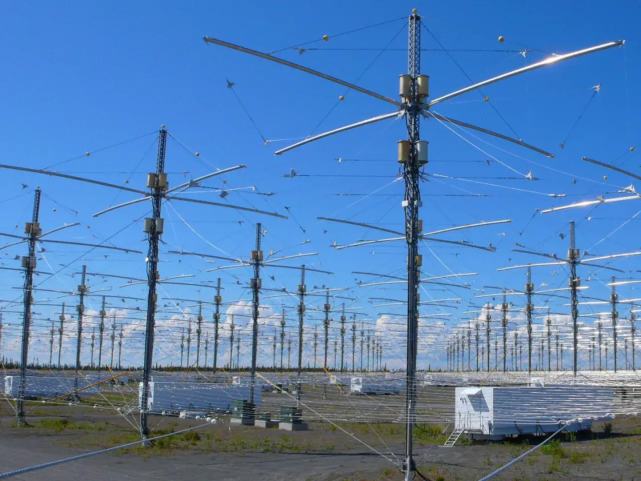 Ogromne pole anten HAARP pod błękitnym niebem.