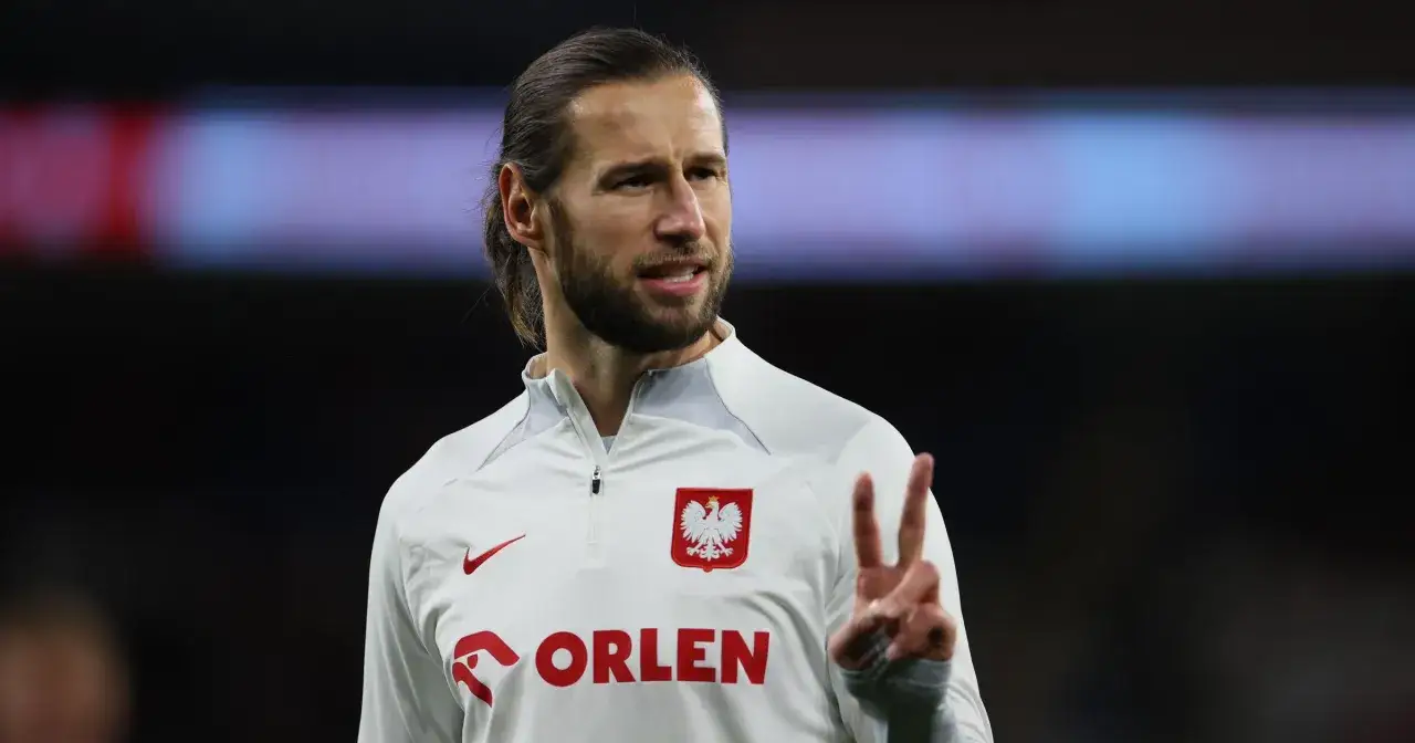 Grzegorz Krychowiak, reprezentant Polski, pokazuje znak zwycięstwa. Gra dla reprezentacji narodowej.