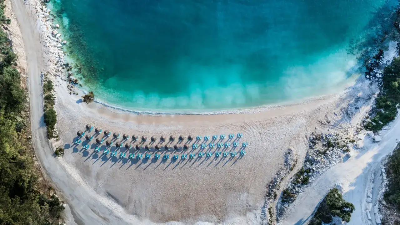 Rajska plaża na Thassos z turkusową wodą i rzędami leżaków. Idealne miejsce na relaks i podziwianie pięknych widoków.
