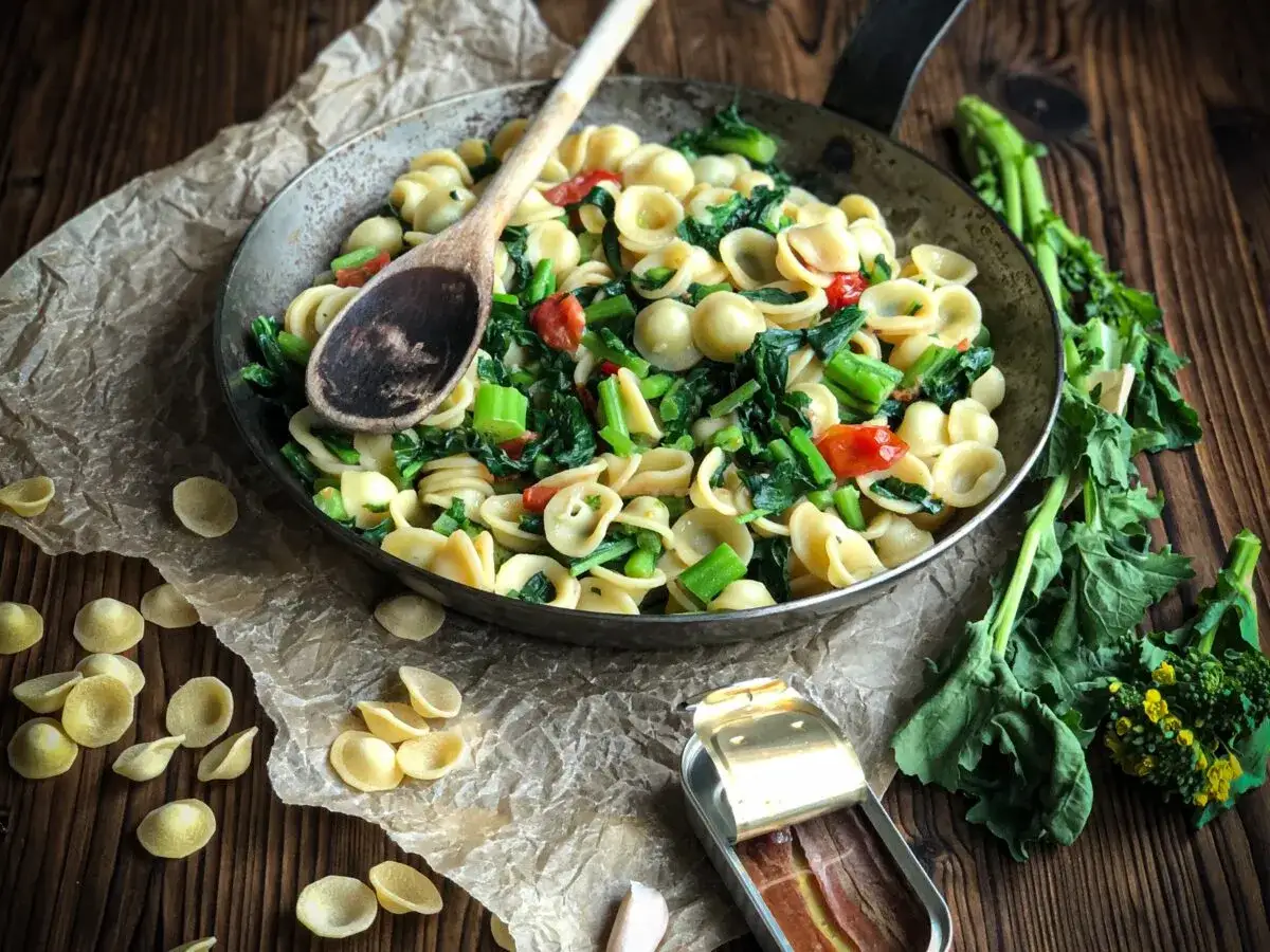 Orecchiette-Pasta mit grünem Gemüse und Tomaten in einer Pfanne, ein köstliches Gericht, das zu den beliebten Orecchiette Rezepten gehört.