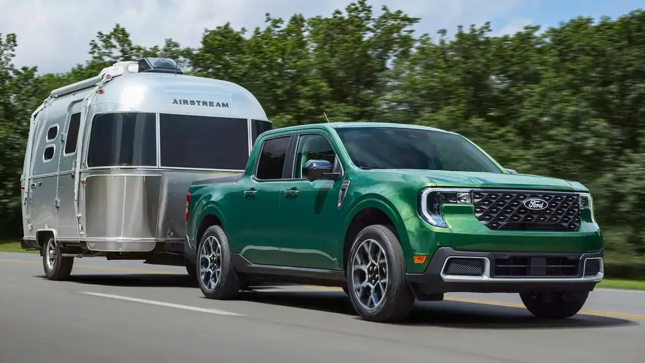 Un pick-up verde traina una roulotte Airstream argentata, un'immagine di libertà e avventura. Tra i migliori pick-up per viaggiare.