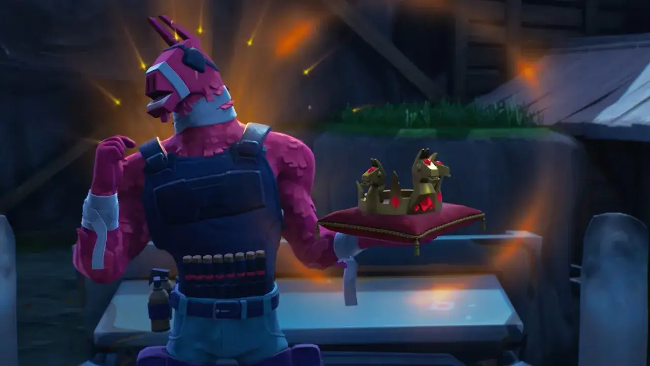 R&oacute;żowy lama z gry Fortnite trzyma złotą koronę na poduszce.