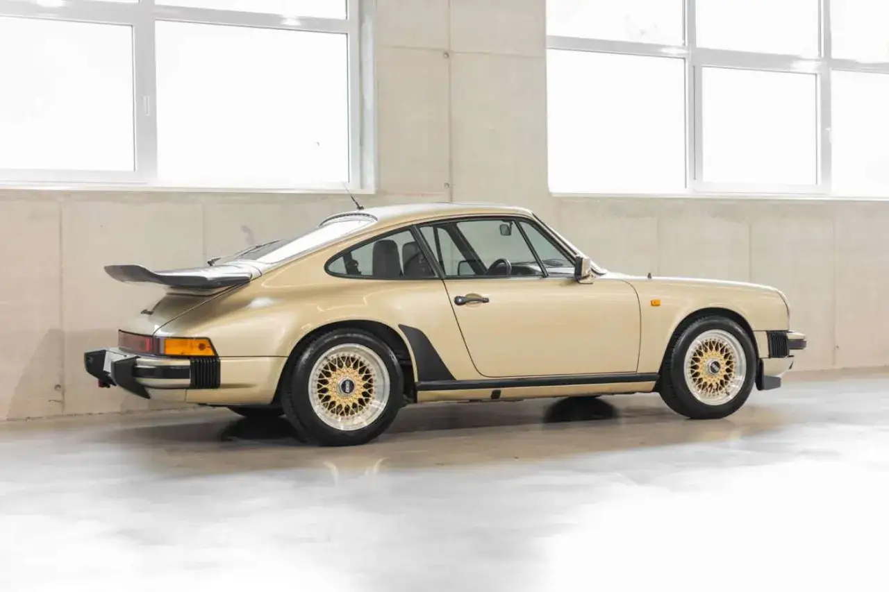 Goldener Porsche 911 3.2 Carrera mit Spoiler und BBS-Felgen, ein Klassiker mit guter Wertentwicklung.
