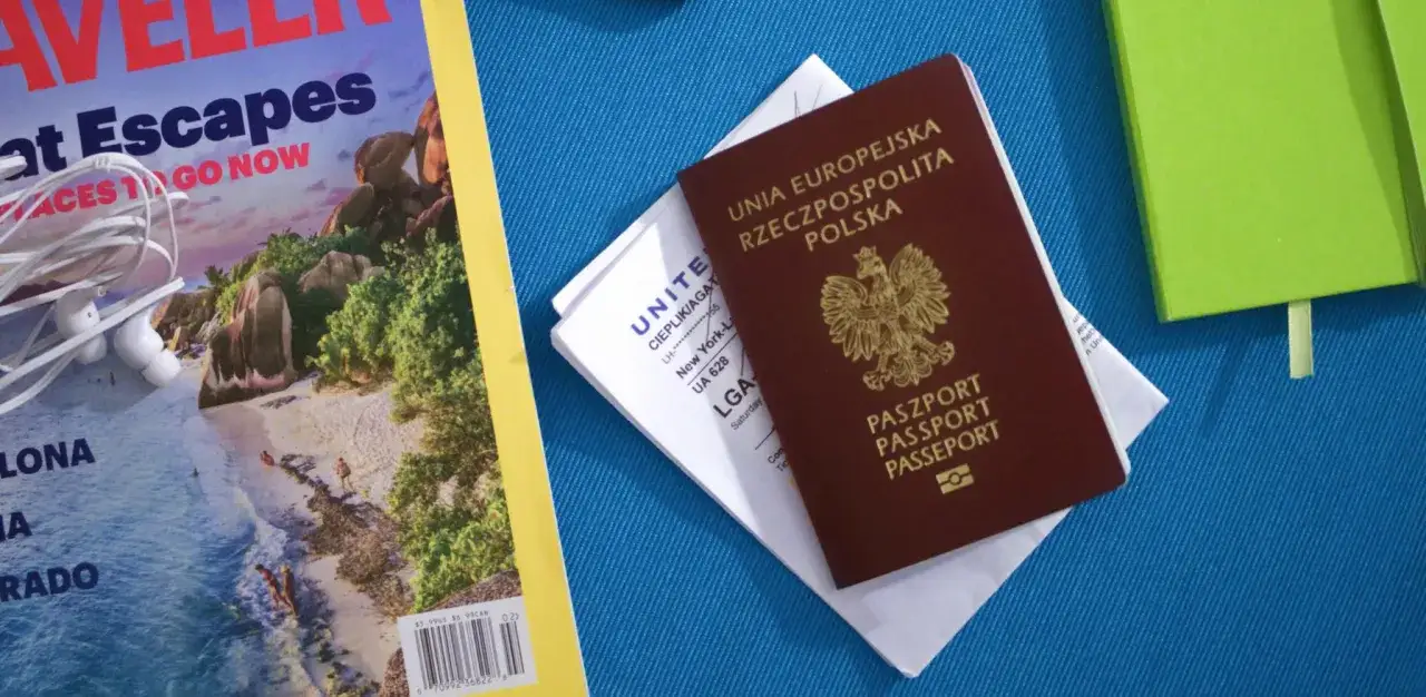 Paszport i bilet lotniczy leżą obok magazynu o podróżach. Czy do Kanady potrzebna jest wiza? Sprawdźmy!
