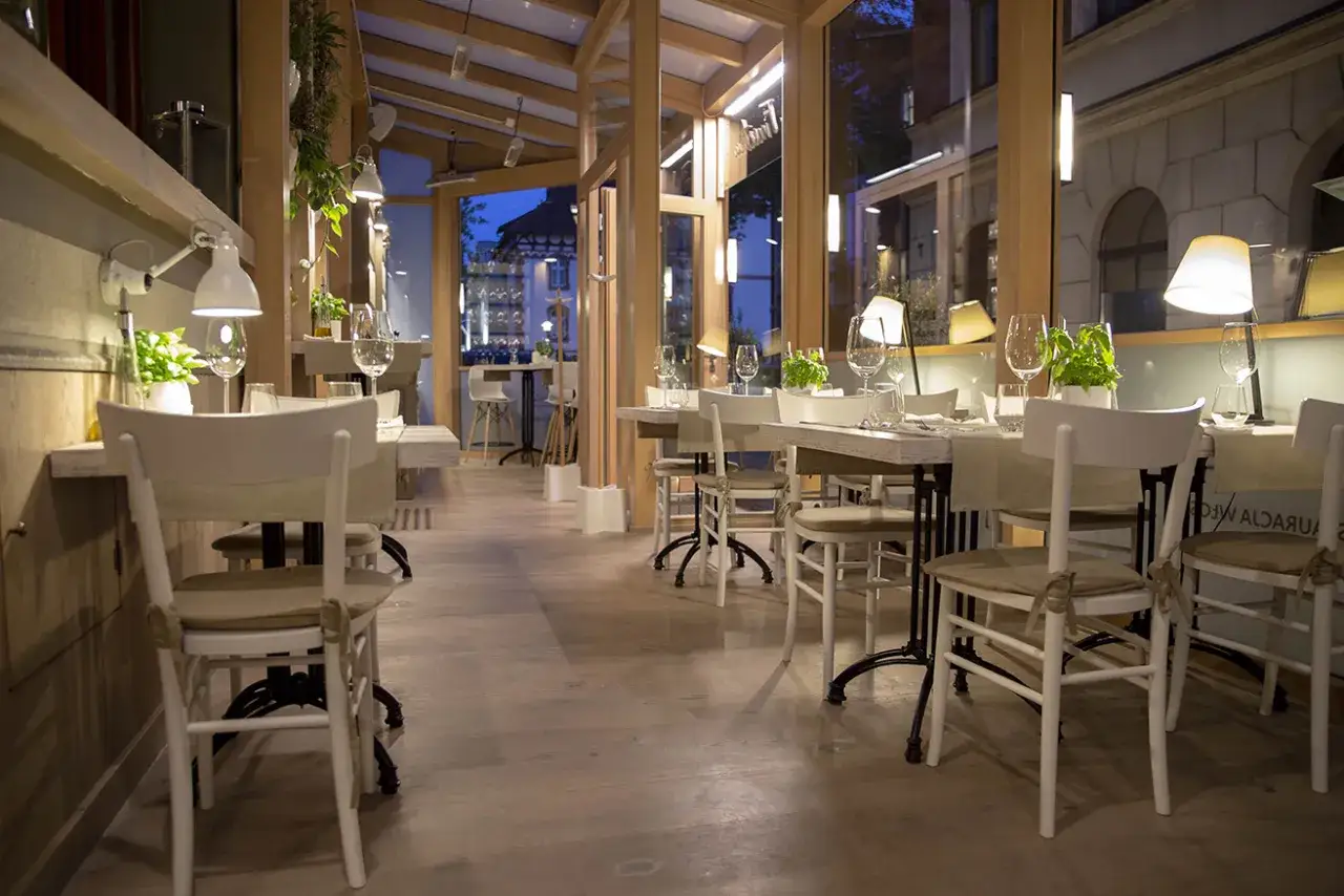 Eleganckie wnętrze restauracji w Opolu, z drewnianymi elementami i przytulnym oświetleniem. Idealne miejsce na romantyczną kolację. Polecane restauracje Opole.