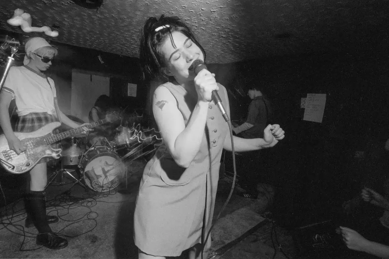 La chanteuse de Bikini Kill hurle dans le micro, la bassiste joue, l'énergie d'un concert punk.