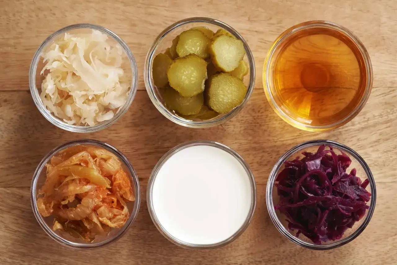 Sex skålar med fermenterad mat: surkål, gurka, äppelcidervinäger, kimchi, yoghurt och rödkål.