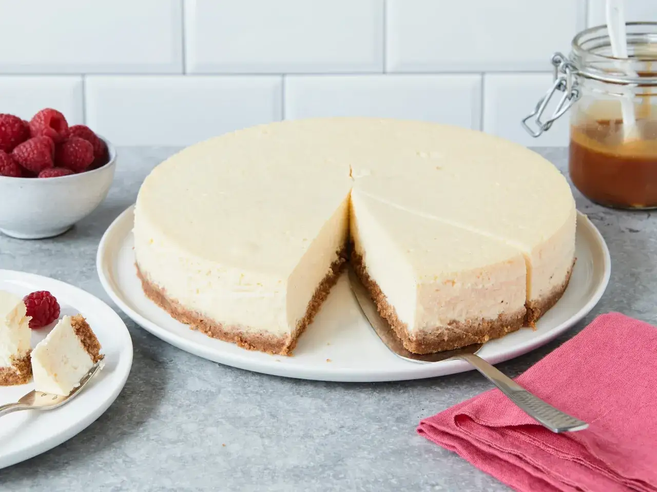 Ein klassischer New York Cheesecake, das Original-Rezept, wird mit frischen Himbeeren und Karamell serviert.