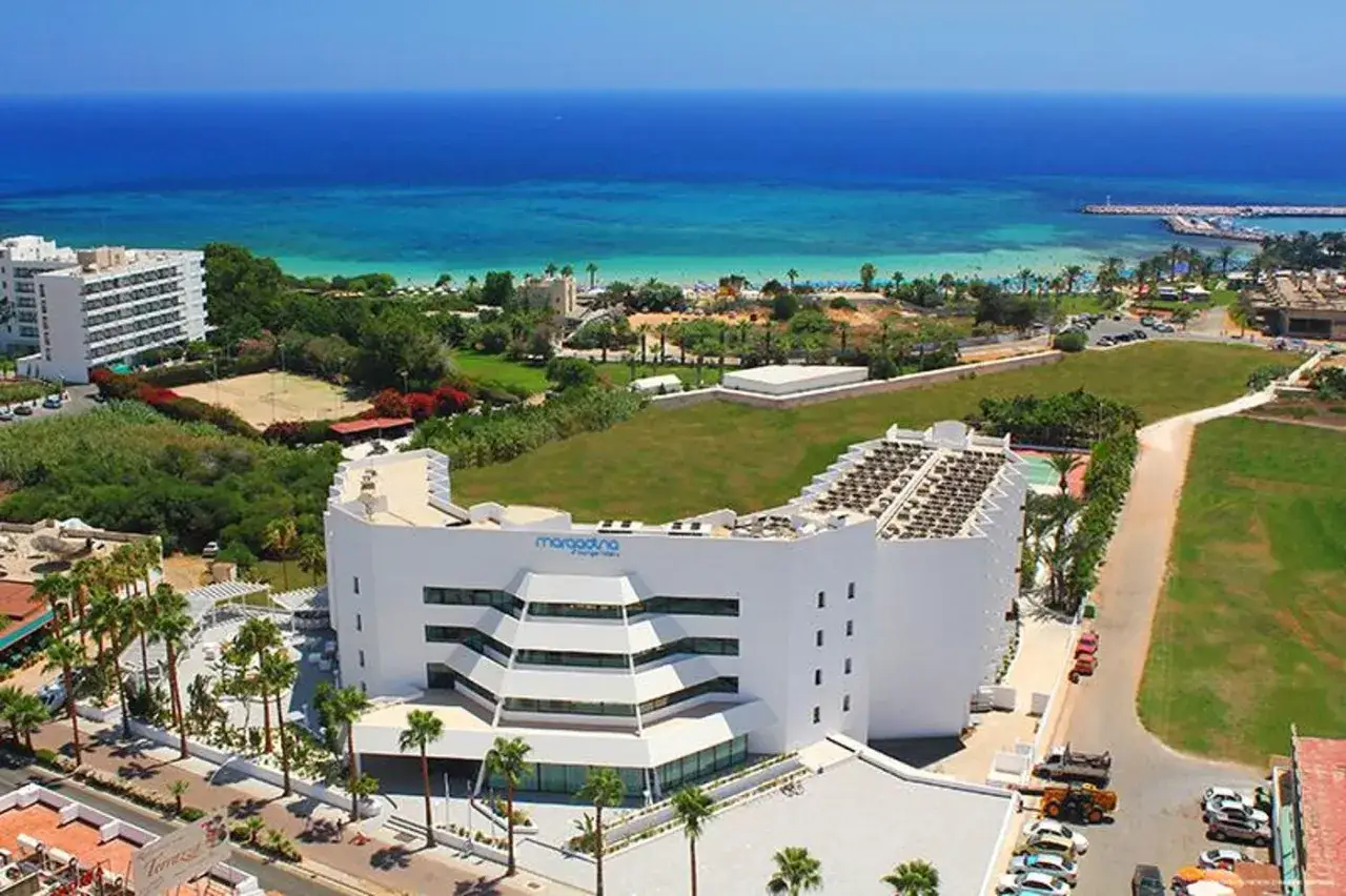 Widok z lotu ptaka na hotel Margadina Lounge, z basenem, palmami i morzem w tle.