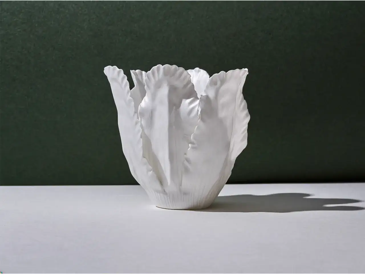 Eine weiße Keramikvase in Tulpenform. Die weiße Farbe bedeutet Reinheit und Eleganz.