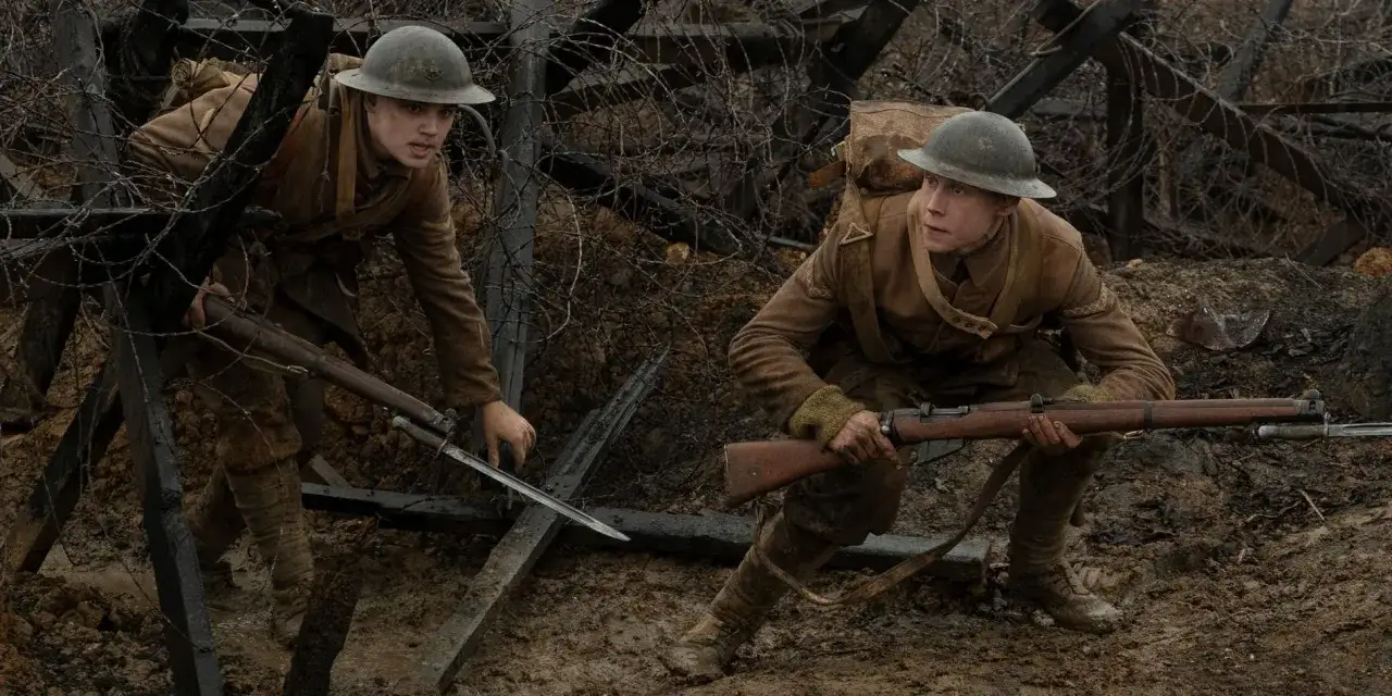 Zwei Soldaten im Schützengraben, bewaffnet mit Gewehren und Bajonetten, kämpfen sich durch Stacheldraht. Szene aus dem Film