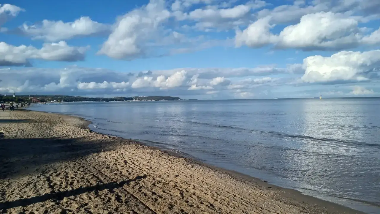 Plaża nad Bałtykiem, gdzie jest najwięcej jodu. Spokojne morze, piaszczysty brzeg i chmury na niebie.